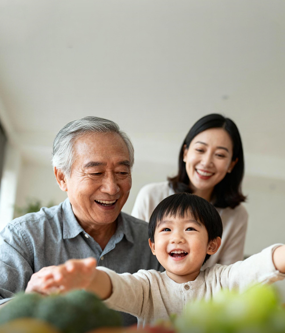 白发老人、中年女士与幼童在明亮室内开怀互动，展现温馨三代同堂场景，传递出幸福美满的家庭氛围，契合生物制药公司守护患者美好生活的理念。